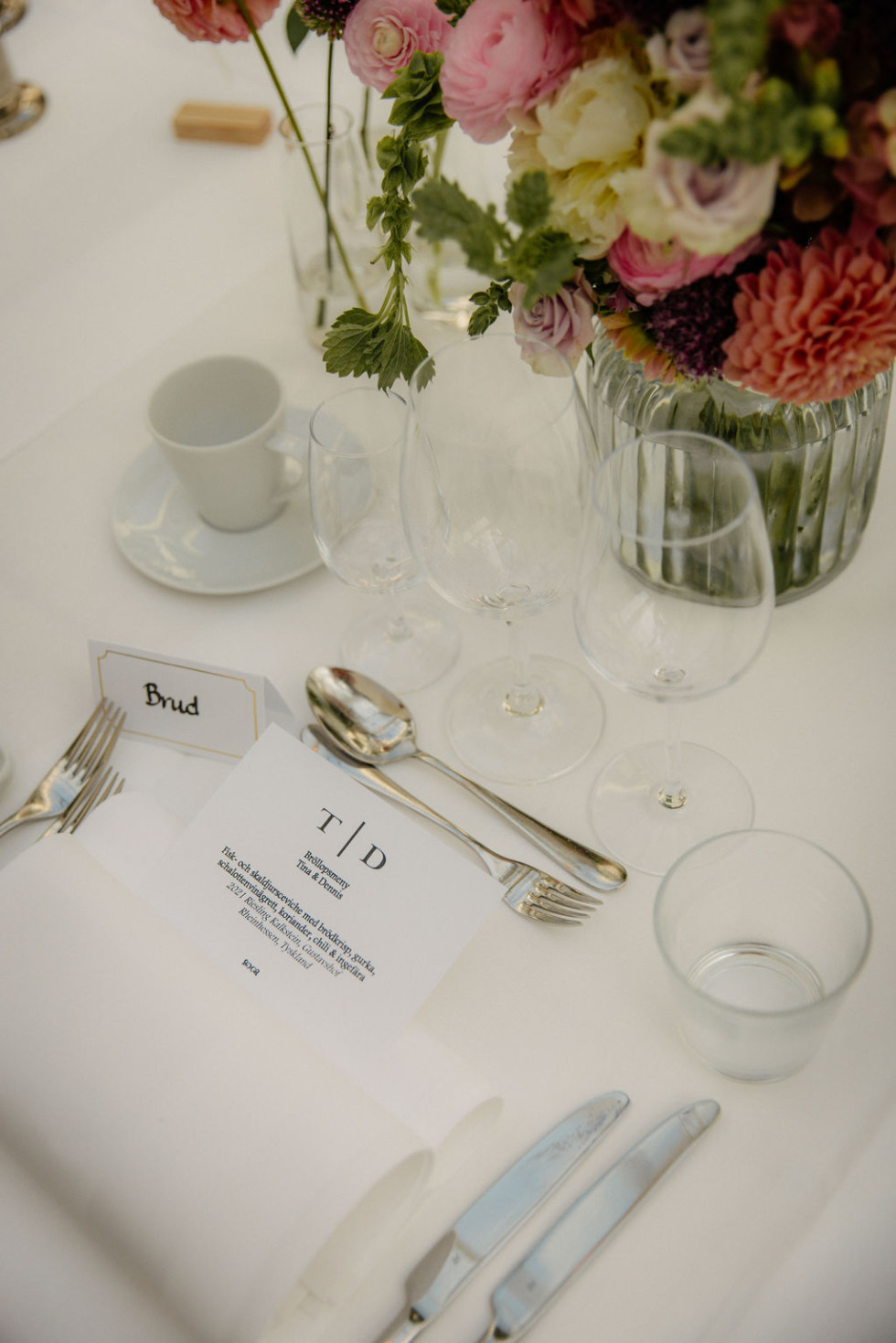 Elegant dukat bröllopsbord med vackra detaljer och blommor, redo för bröllopsfesten.