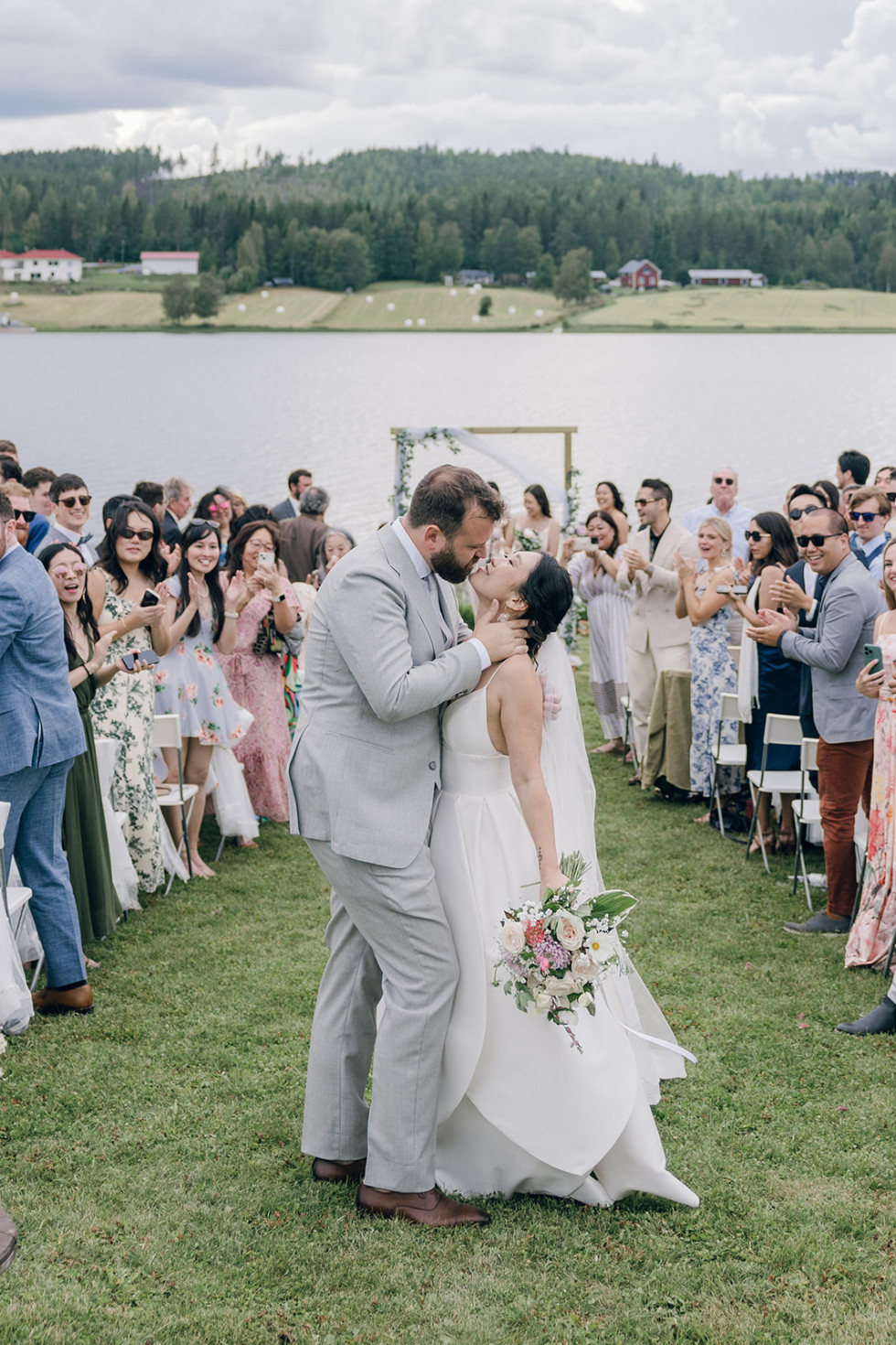 ett brudpar som kysser varandra vid vattnet