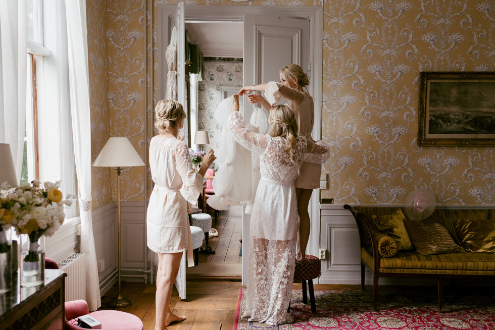 sätter på sig klänningen