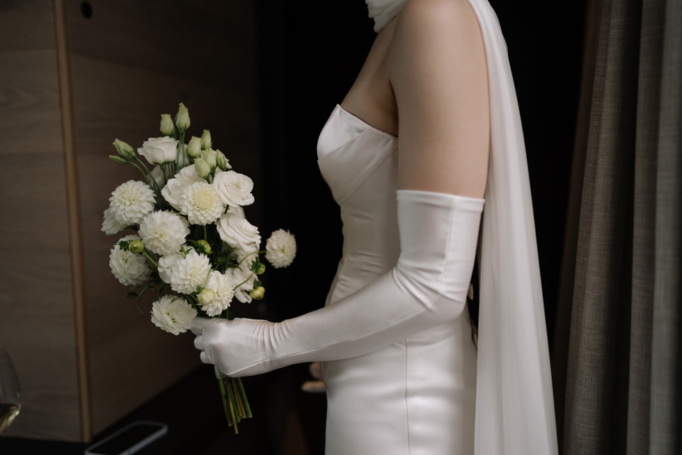 Bruden håller sin bukett med stolthet och elegans, en viktig detalj på bröllopsdagen.