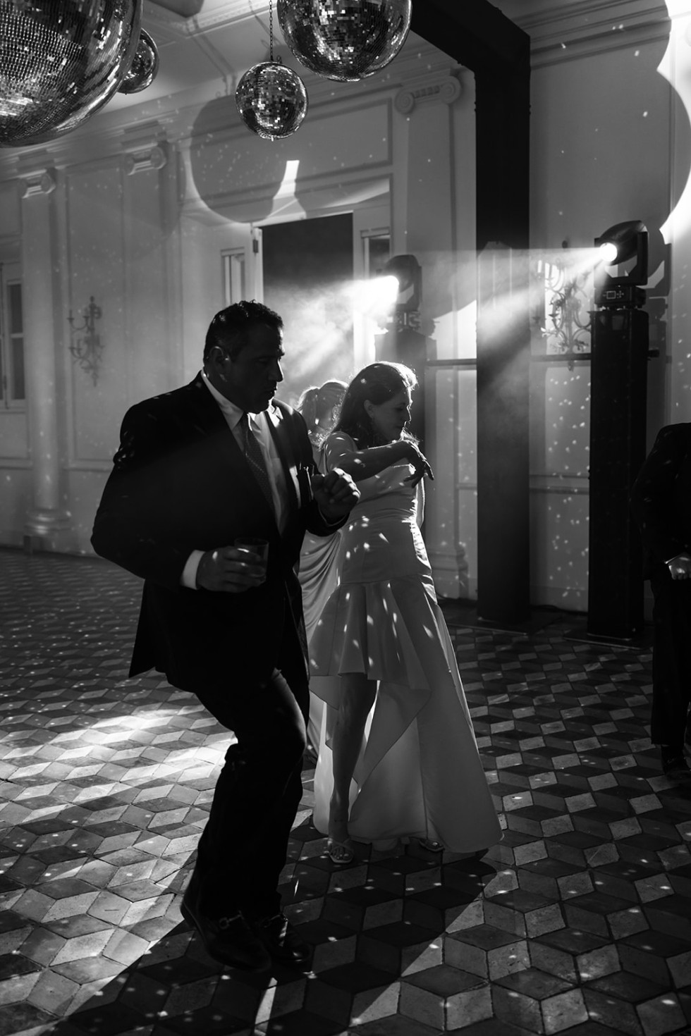 Gäster i olika åldrar dansar under glittrande ljus på dansgolvet.