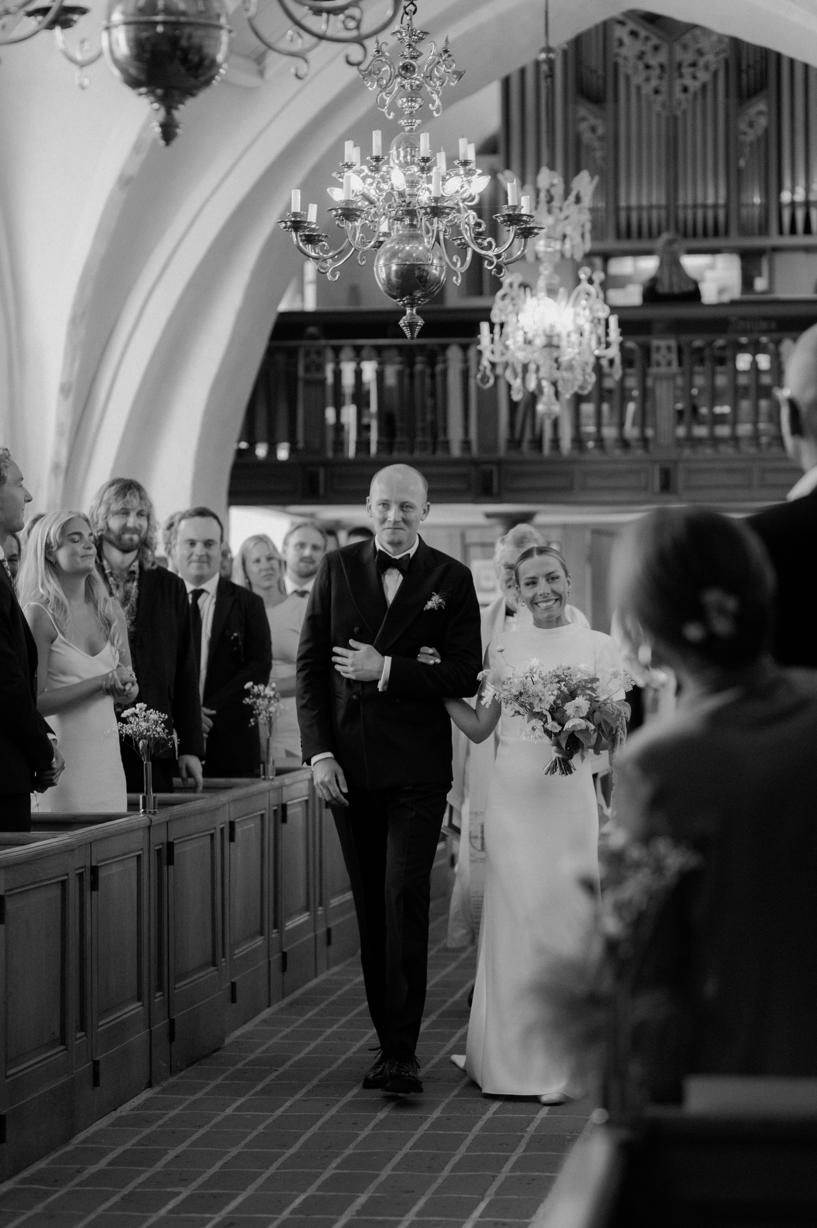 Ett lyckligt brudpar vandrar ut efter sin vigselceremoni i kyrkan