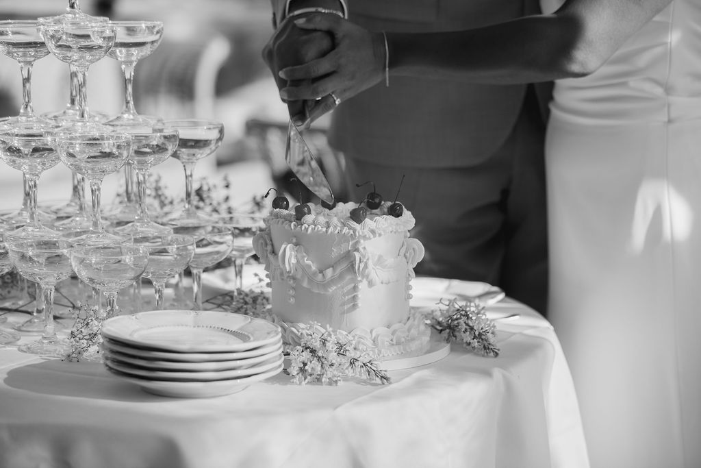 Ett bröllopsbord fyllt med glas och en vacker bröllopstårta som ska delas under en festlig mat bröllopsfest